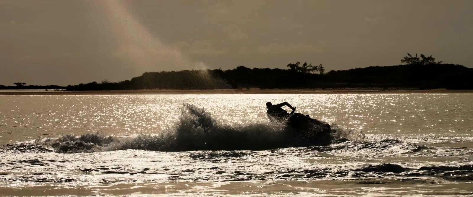 A WaveRunner carving through golden water at sunset